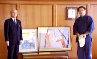 新作の絵と共に市長と歓談する鈴木氏