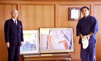 新作の絵と共に市長と歓談する鈴木氏